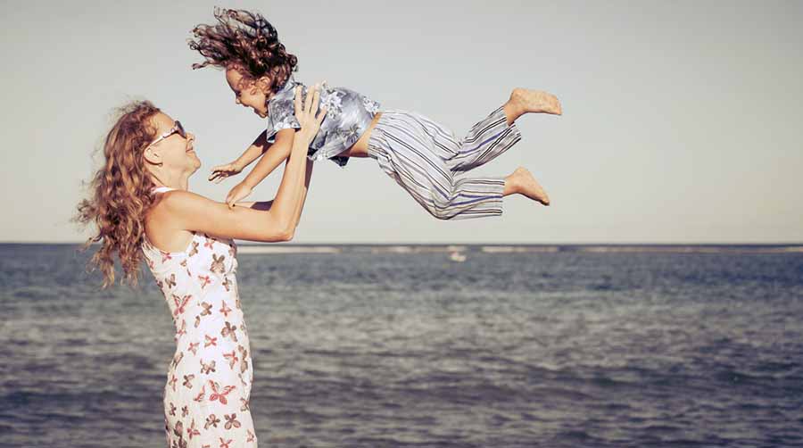mother and son playing on the beach at the day time